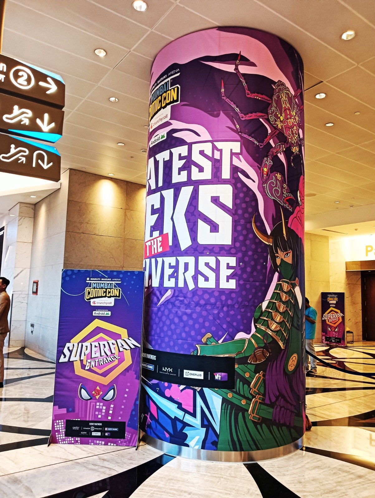 Pillar Branding — Full-height wrapped pillar graphics with matching entrance standees.